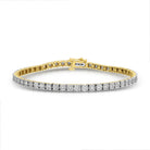 A yellow gold tennis bracelet featuring a series of round diamonds set in a prong setting.