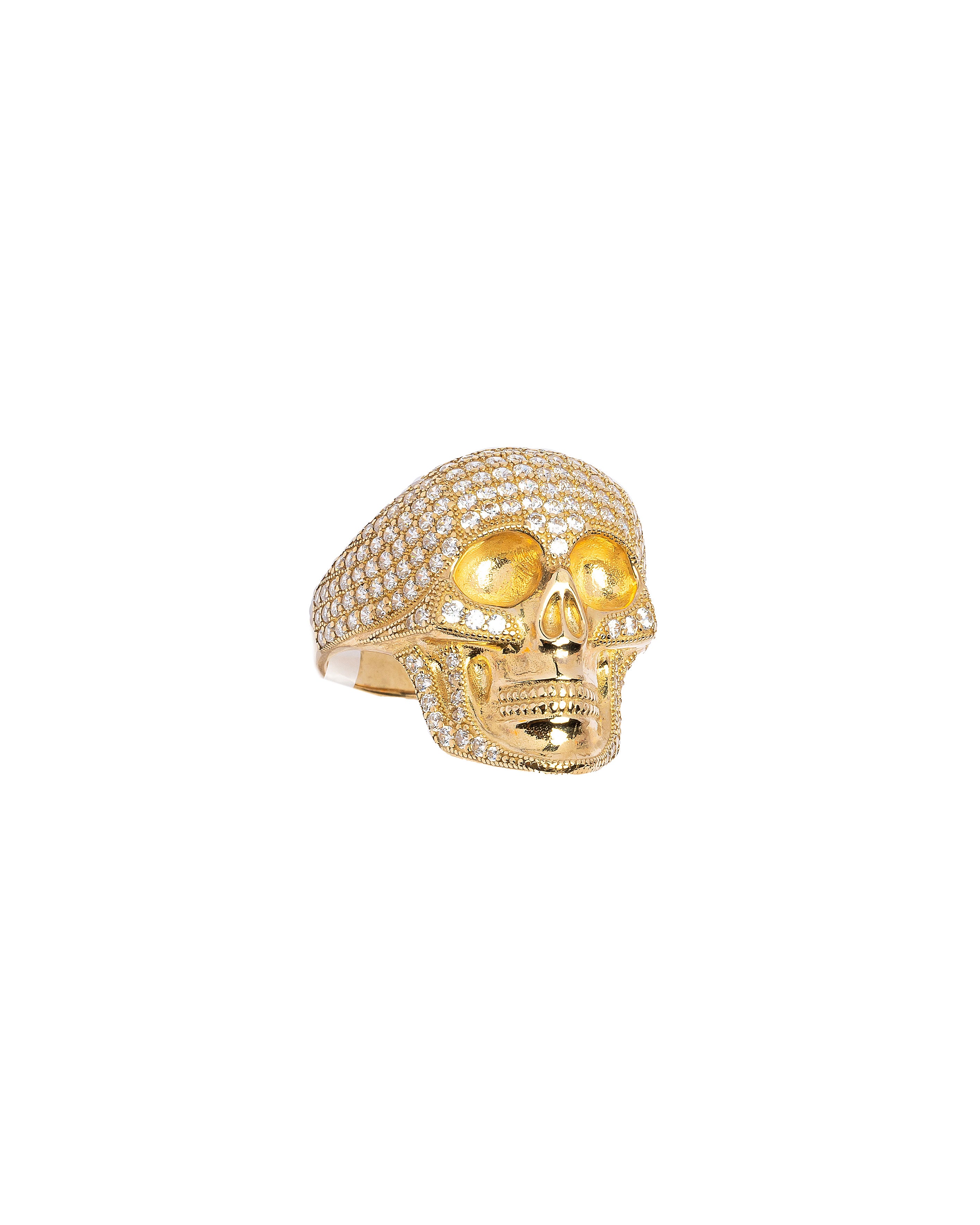 Gold skull ring with embedded stones on a white background