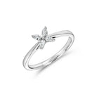 A 10k white gold ring with a flower-shaped design containing a lab diamond at the center, placed on a plain background.