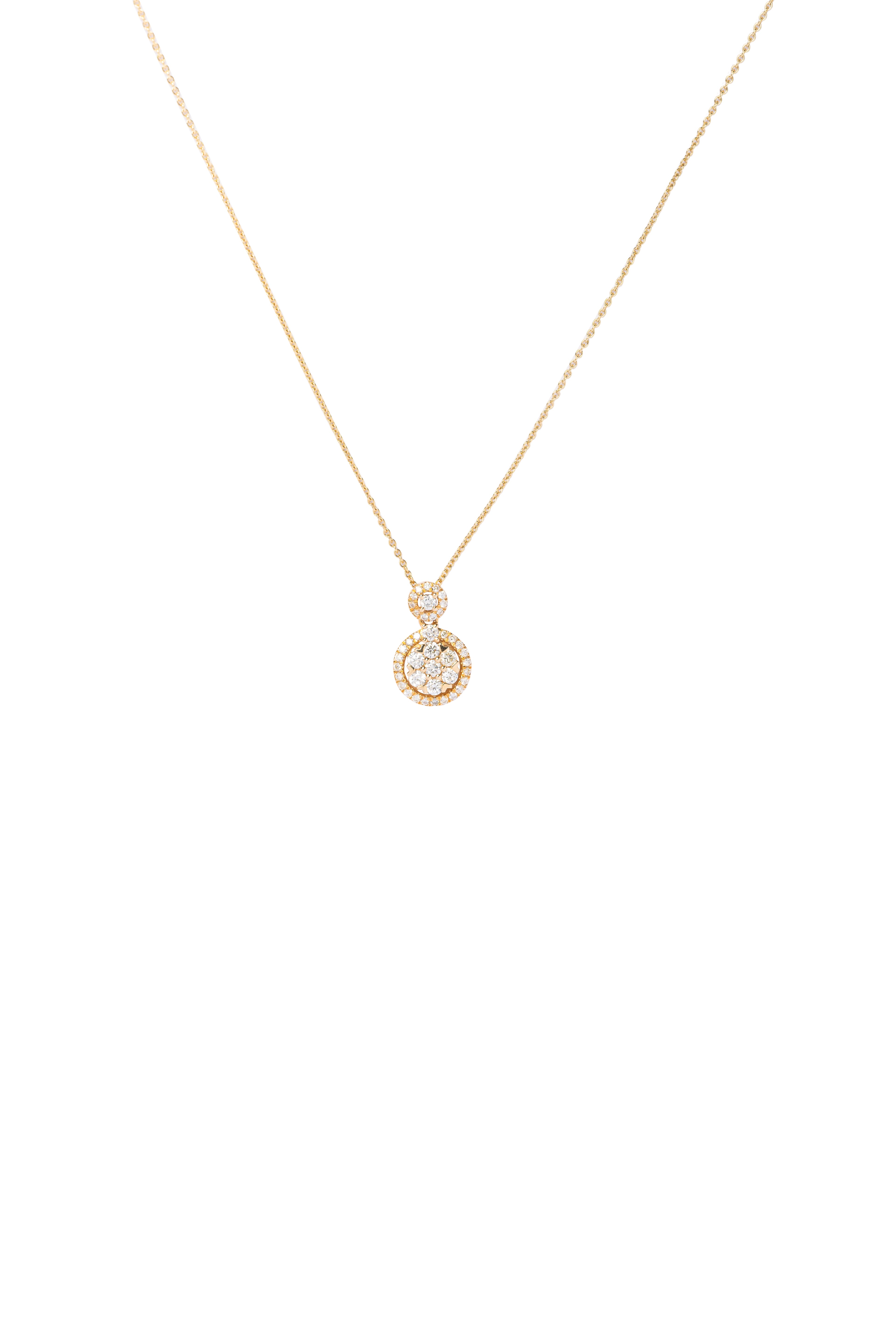 Gold necklace with a small round pendant on a white background