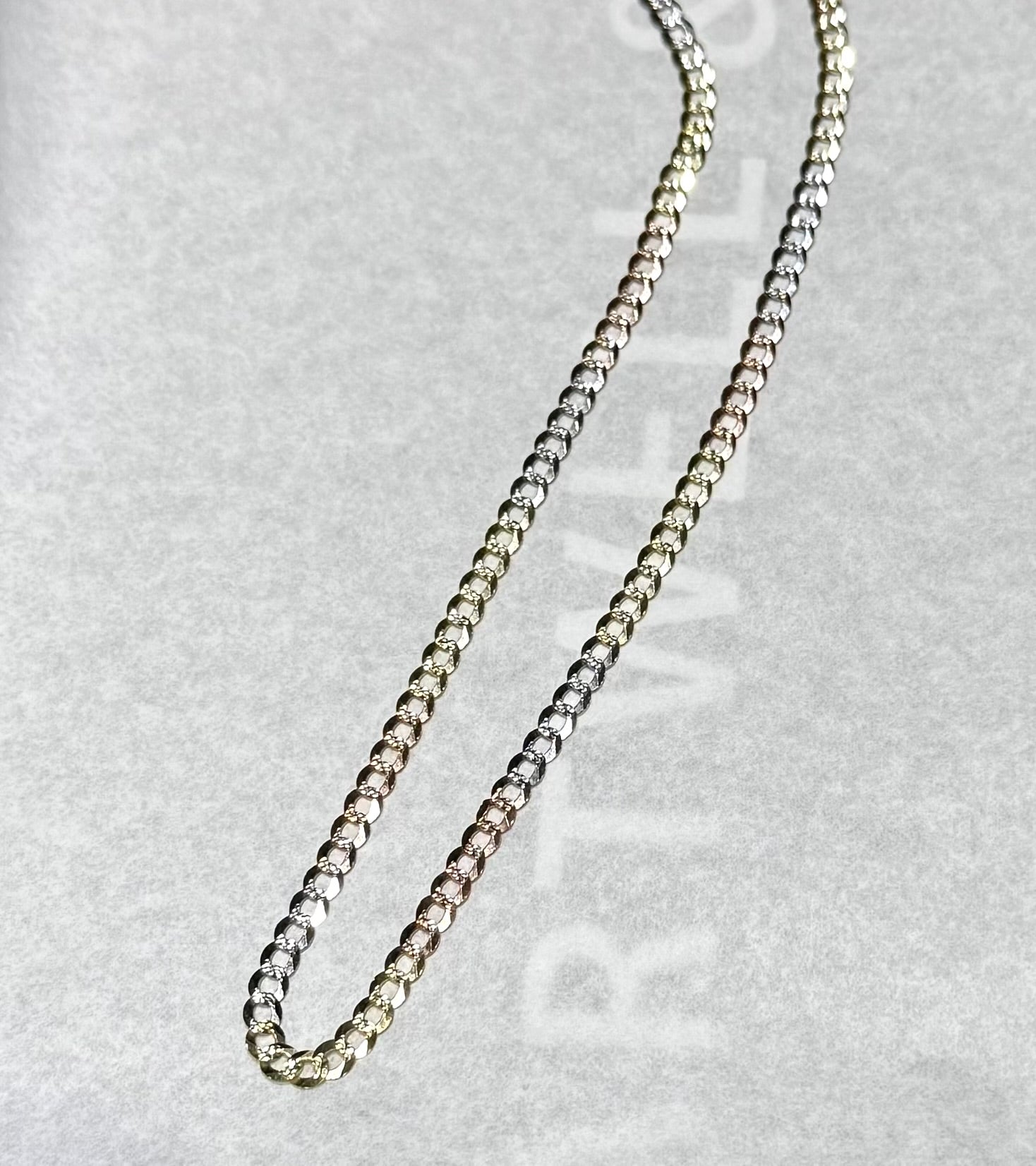 A 14K yellow tri color curb Cuban chain necklace with a lobster clasp, displayed against a white background.
