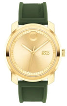 Gold watch with green strap on a white background